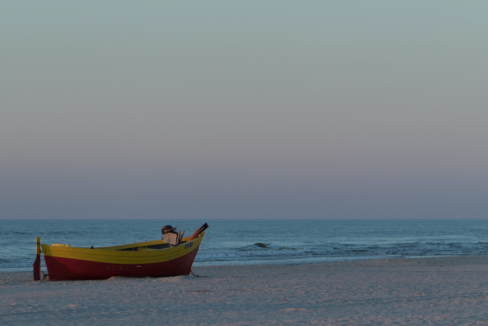 yellow and red boat on sea during daytime