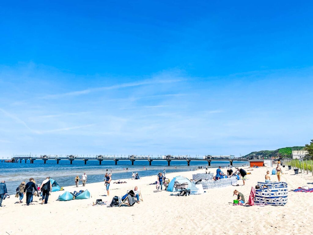 Der weiße Sand am Strand von Misdroy mit der Seebrücke im Hintergrund