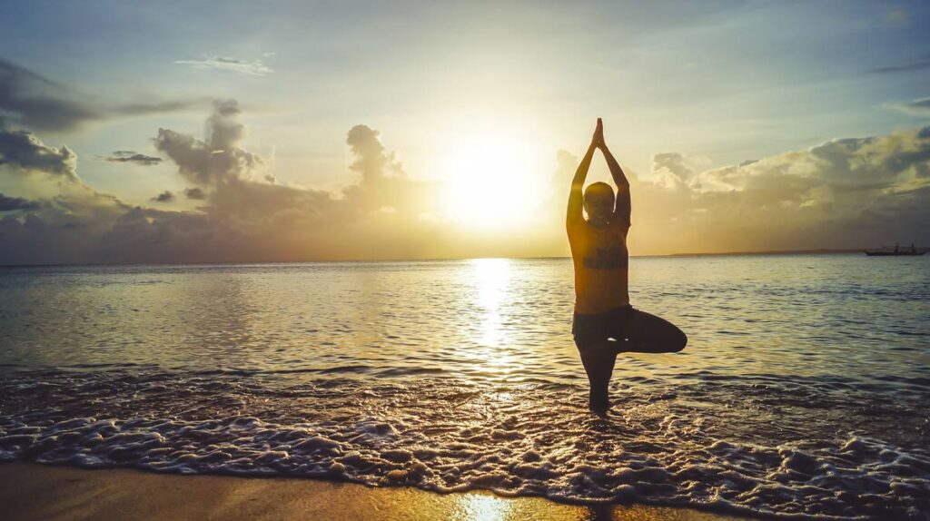 Person macht Wellness Yoga in den Wellen der Ostsee