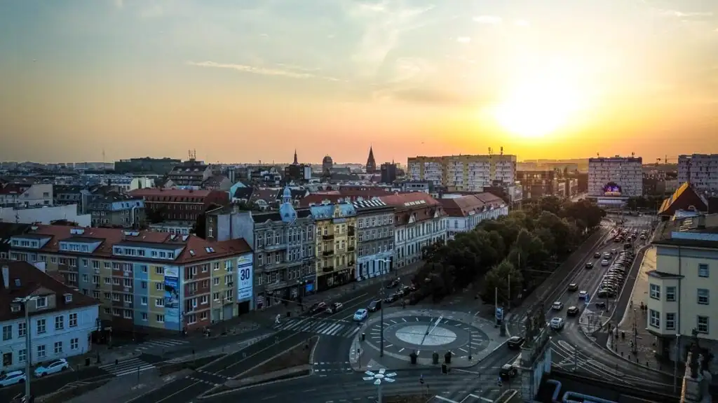 Sonnenuntergang über den Häusern der Stadt, die Dächer in warmes Licht getaucht.