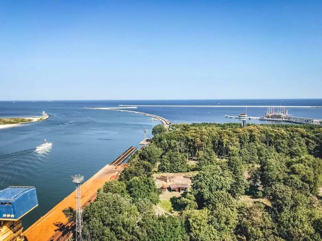 Blick vom Leuchtturm in Swinemünde Richtung Ostsee: Ein beeindruckendes Panorama erstreckt sich über das weite Blau der Ostsee, mit dem endlosen Horizont und dem goldenen Sandstrand im Vordergrund – perfekt für einen Moment der Ruhe und Weite.