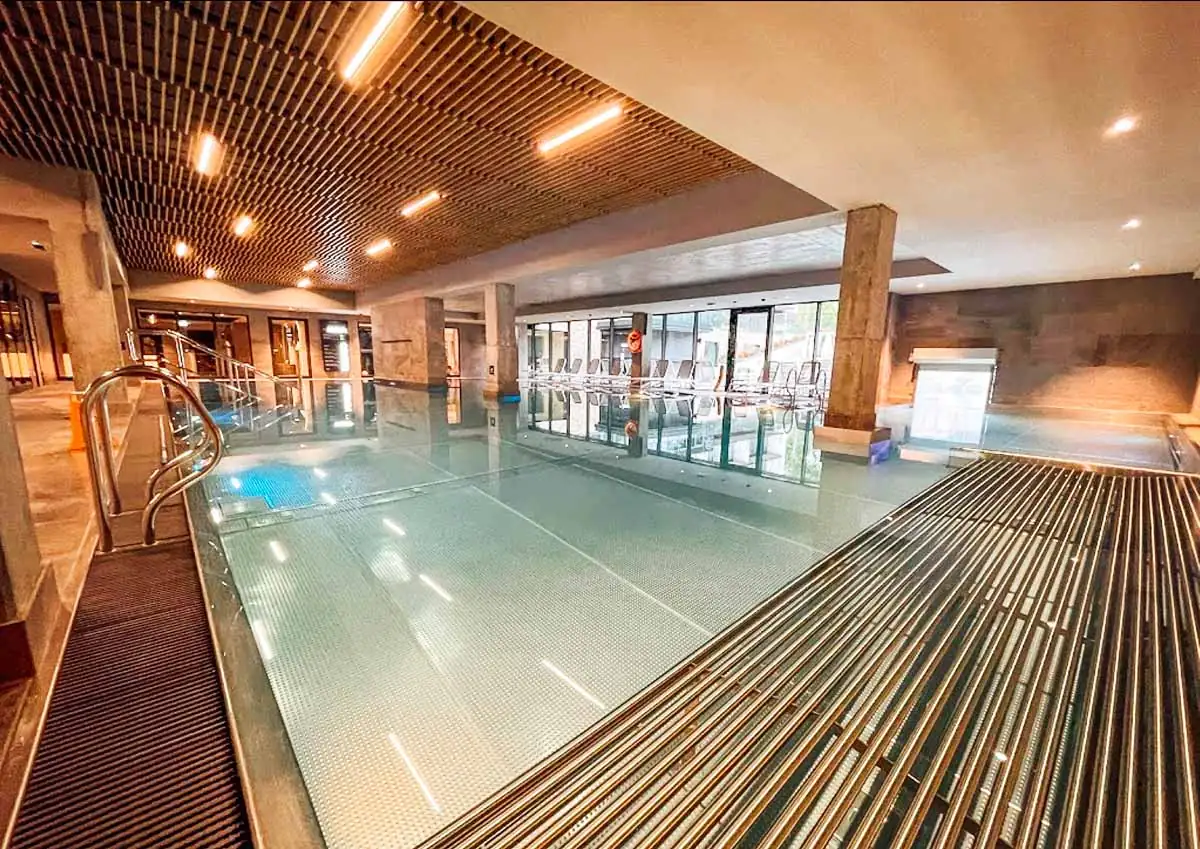 Innenpool im Radisson Resort Kolberg, umgeben von Liegen, als Teil des Wellnessbereichs mit Saunen und Massagen.