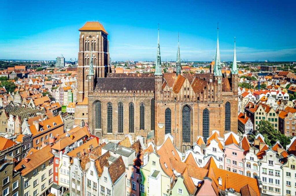 Luftaufnahme der St. Marienkirche in Danzig, der größten Backsteinkirche der Welt, umgeben von den historischen Häusern der Altstadt.