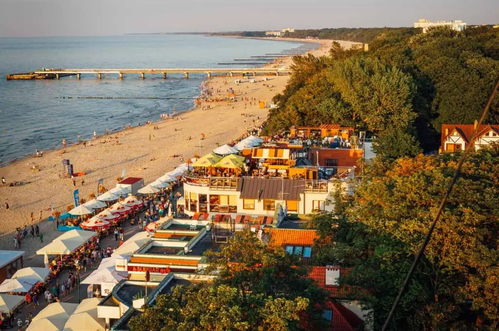 Kolberg Strand und Promenade vom Leuchtturm – Aussicht vom Leuchtturm auf die Kolberger Strandpromenade, die weiten Sandstrände und das Meer der Polnischen Ostseeküste.