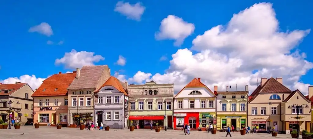 Marktplatz von Darłowo mit farbenfrohen Häusern, barockem Rathaus und historischen Fassaden.