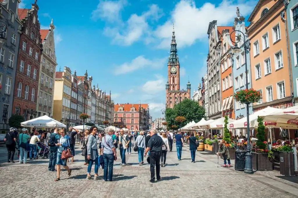 Langer Markt in Danzig mit Rathaus im Hintergrund, historische Gebäude und Fußgängerzone.