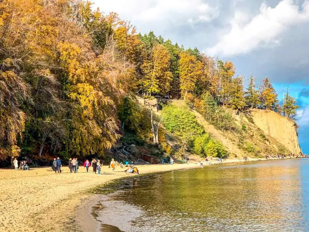 Strand von Redłowo in Gdynia an der Polnischen Ostsee mit Steilküste und bewaldeten Hügeln im Hintergrund