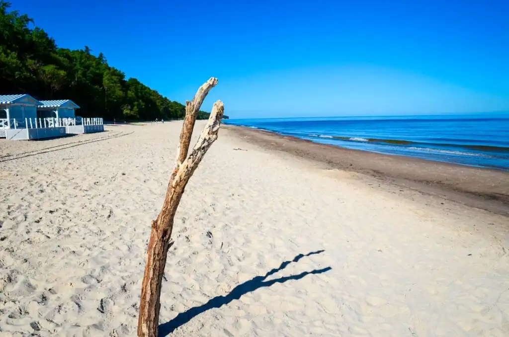 Leerer Sandstrand von Pobierowo am Morgen, mit sanften Wellen der Ostsee.