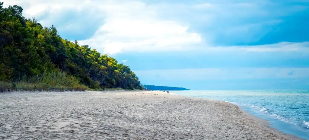 Ein menschenleerer, weitläufiger Sandstrand in Pobierowo am frühen Morgen oder in der Nebensaison.