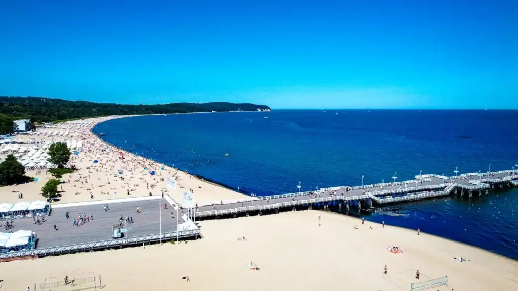 Drohnenaufnahme von Sopot mit Mole, Sandstrand und der weiten Danziger Bucht bei Tageslicht.