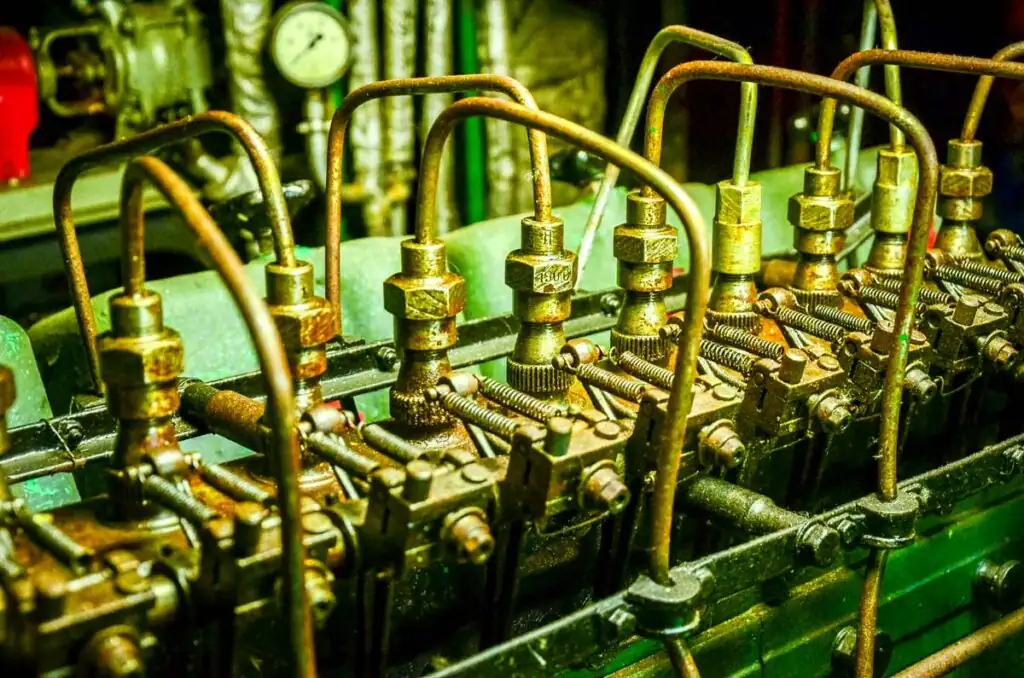 Ausgestellter alter Schiffsmotor im Maritimen Freilichtmuseum Kolberg mit weiteren maritimen Objekten im Hintergrund