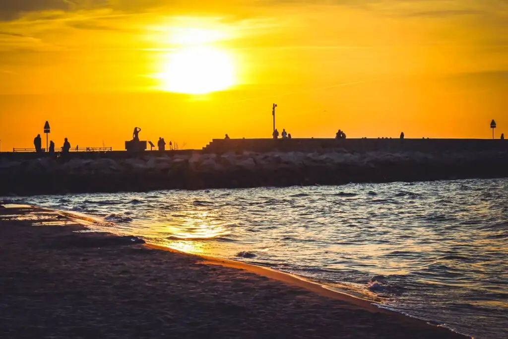 Mole von Ustka mit Meerjungfrau-Statue im Sonnenuntergang an der Polnischen Ostsee