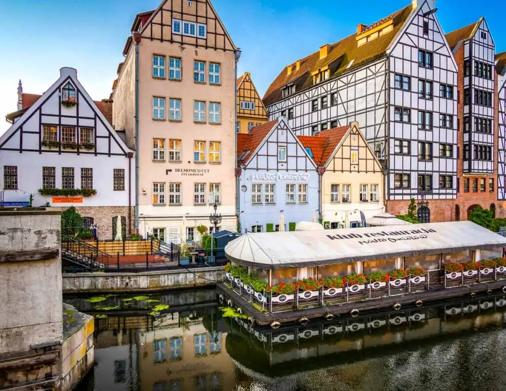 Außenansicht vom Restaurant und Club Miasto Aniołów in Danzig mit beleuchteter Terrasse und Wasserblick am Abend.