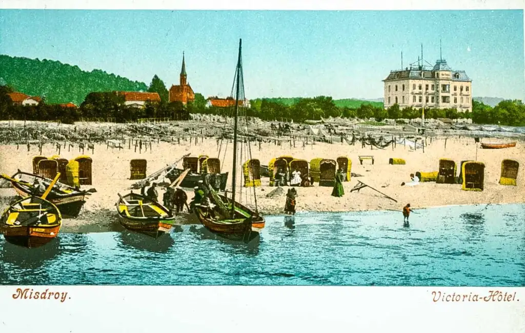 Misdroy (Międzyzdroje) um 1898: Blick vom Hafen auf den Strand mit Fischerbooten und ein großes Hotel an der Promenade (historische Grafik)