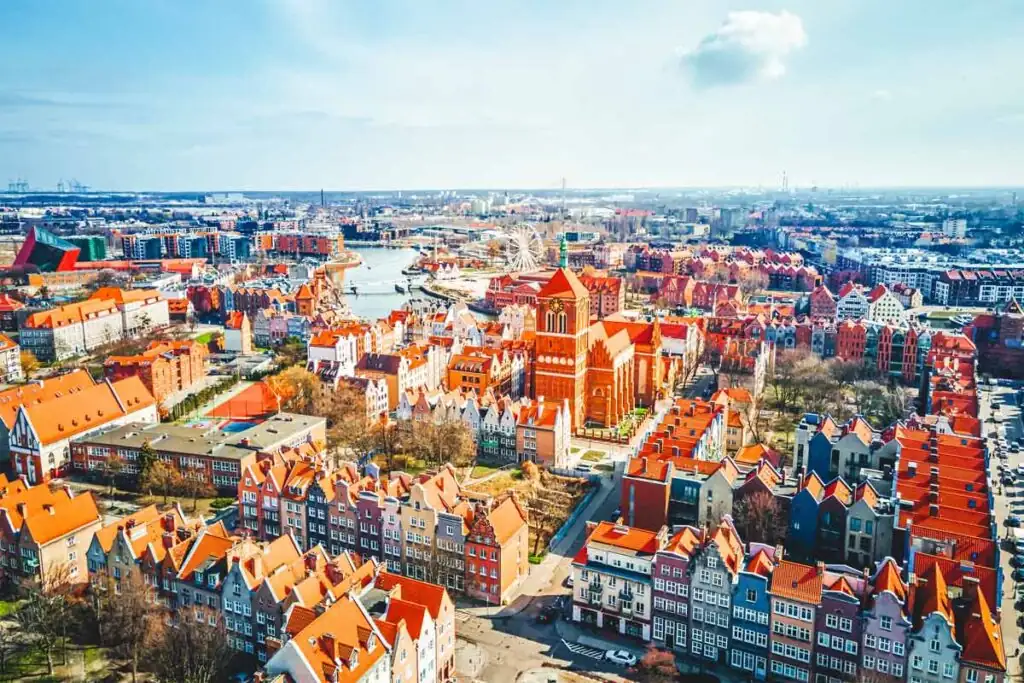 Luftaufnahme von Danzig (Gdańsk) mit der Marienkirche, der Altstadt und der Mottlau, im Hintergrund moderne Hafen- und Wohnviertel.