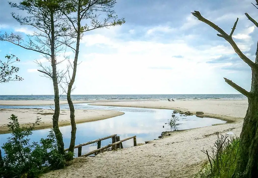 Blick auf die Mündung des Flusses Piaśnica in Dębki, links der FKK-Strandabschnitt, rechts der normale Badestrand an der polnischen Ostsee.