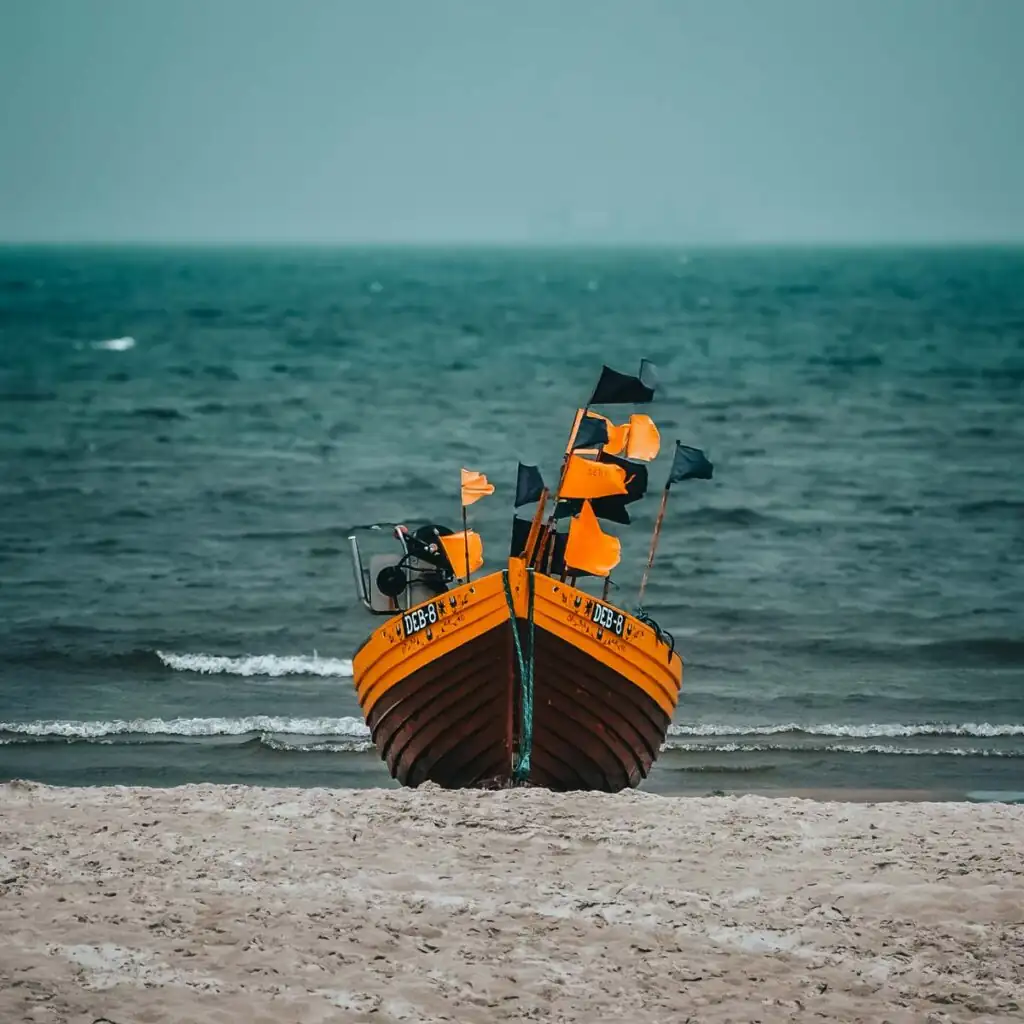 Traditionelles Fischerboot liegt auf dem Sandstrand von Dębki an der polnischen Ostsee.