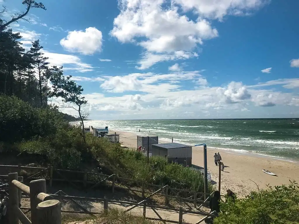 Holztreppe führt durch die Dünen hinab zum Strand; im Hintergrund die Ostsee. Auf der Etappe Łeba–Władysławowo erreicht man hier die Küste für eine Badepause.